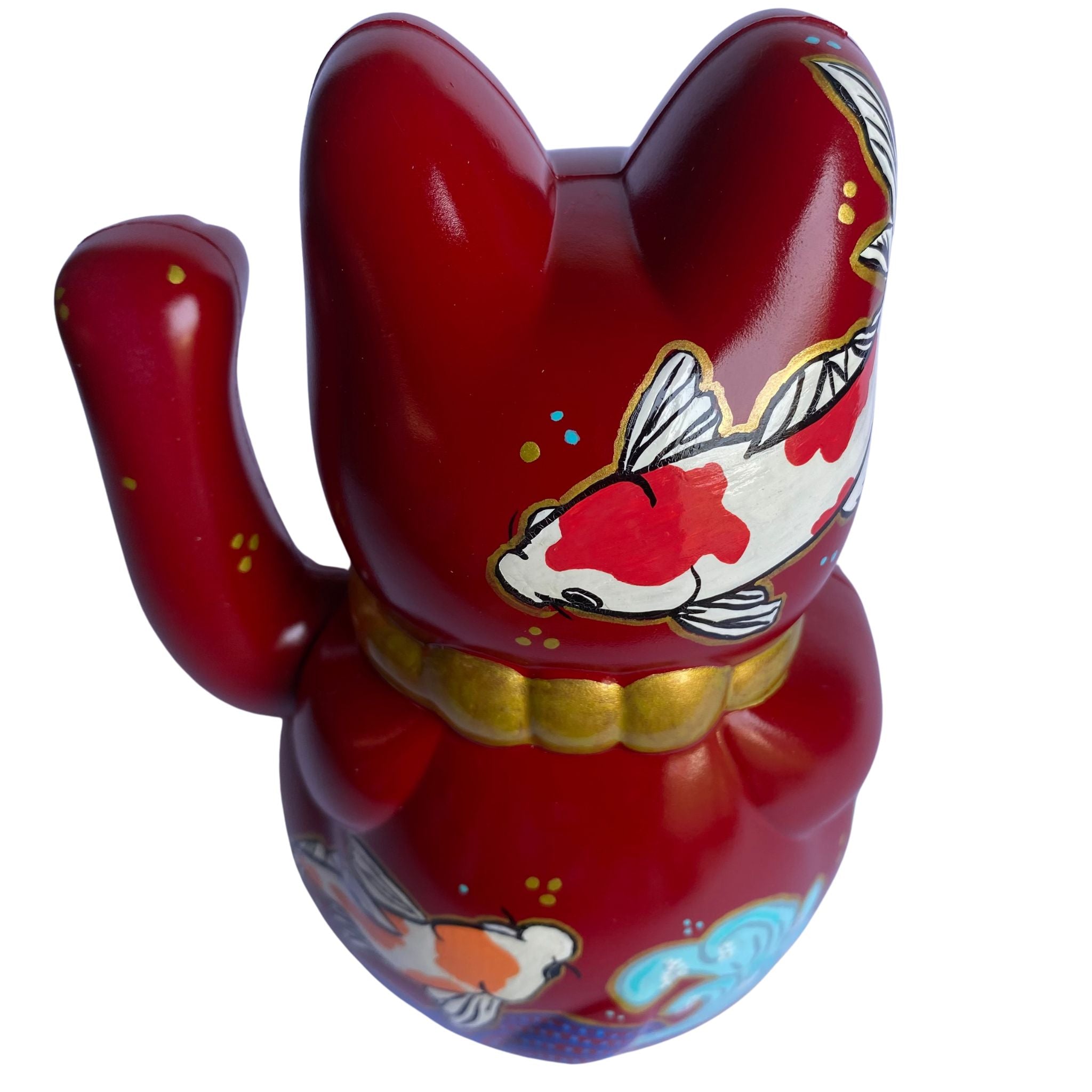 Red lucky cat figurine with a fish design on a white background