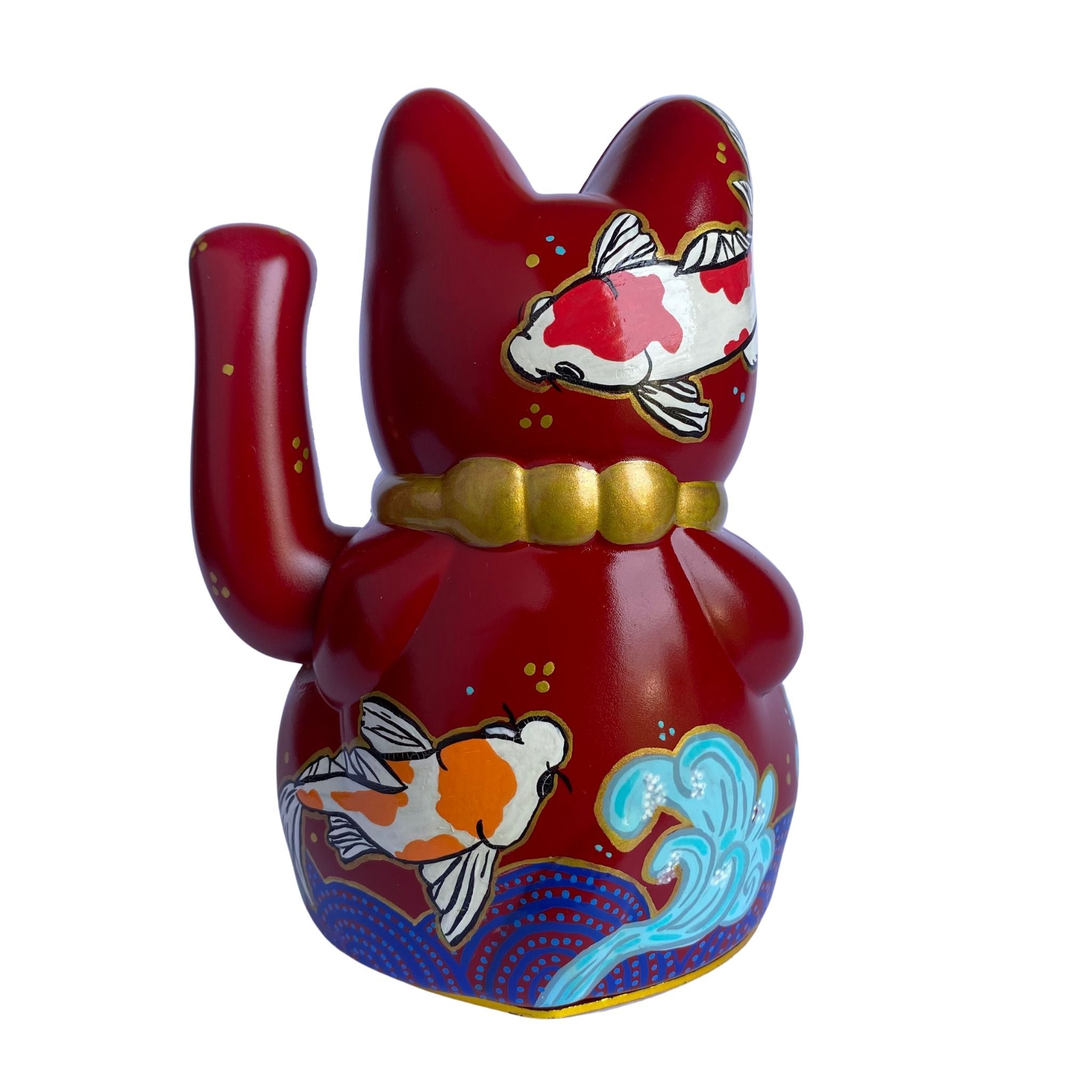 Red cat-shaped figurine with goldfish designs on a white background
